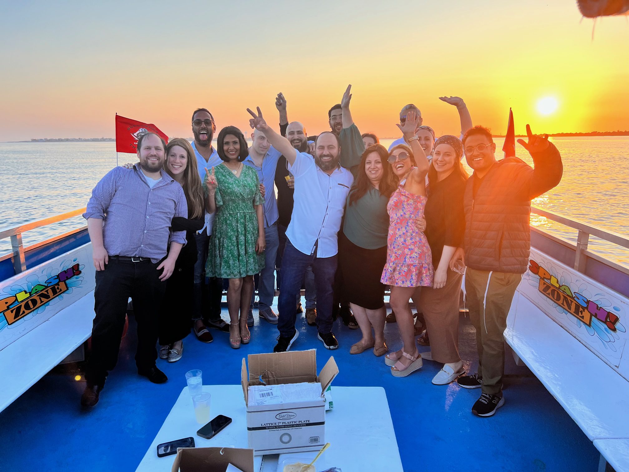Group celebrating on a boat at sunset