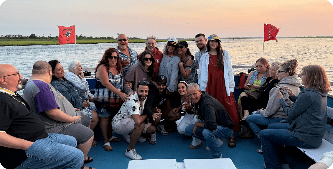 People posing on a boat at sunset