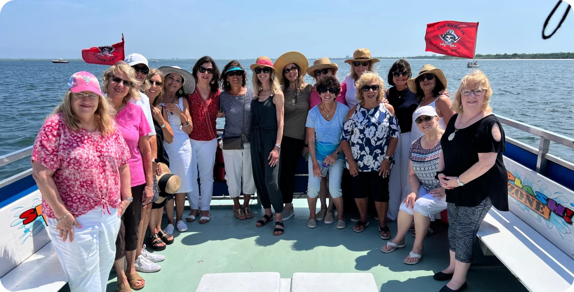 Friends posing on boat with pirate flags