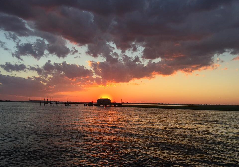 Sunset over calm waters with pier
