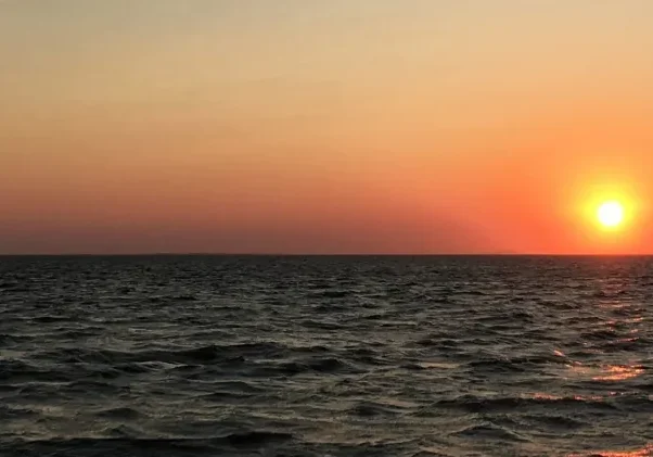 Sunset over calm ocean waves